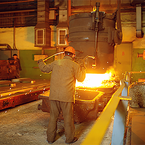 steelmaker pours liquid metal from basket factory