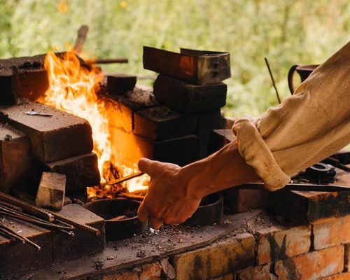 a-blacksmith-hardens-steel-at-high-temperature-in-